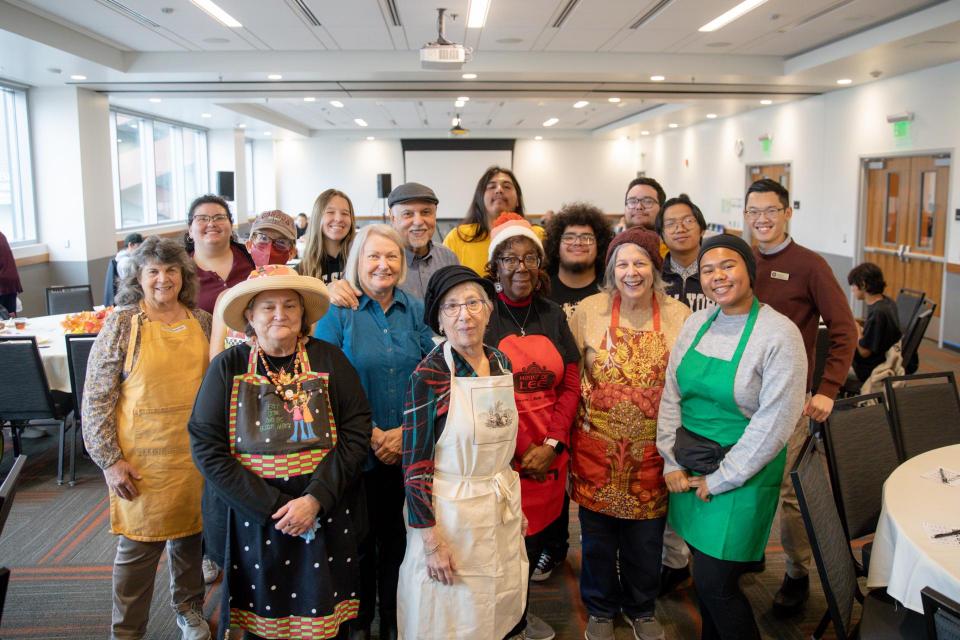 Volunteers huddled together in a group photo, ready to welcome guests to Friendsgiving Feast for a shared sit-down meal.