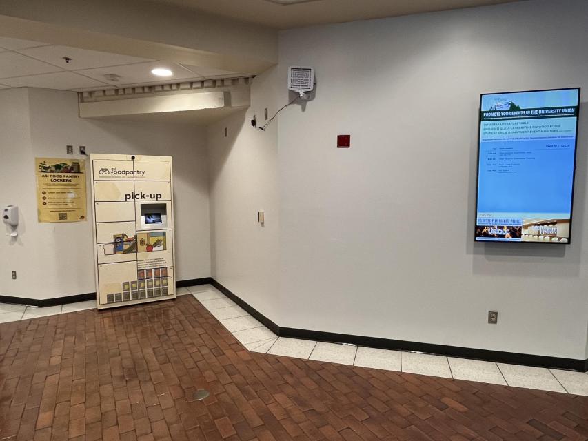 An image of the ASI Food Pantry's lockers unit with a TV screen next to it.